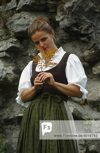 Frau  30 Jahre  in der Reichraminger Tracht posiert vor einer Steinmauer  Oberösterreich  Österreich  Europa