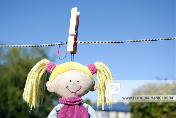 A child's soft toy hanging on washing line to dry after being washed