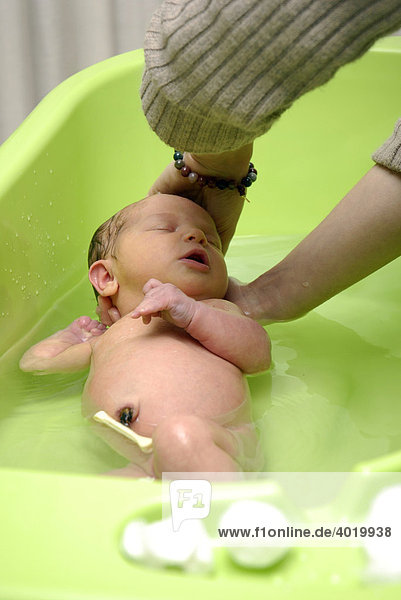 Ein Neugeborenes wird gebadet