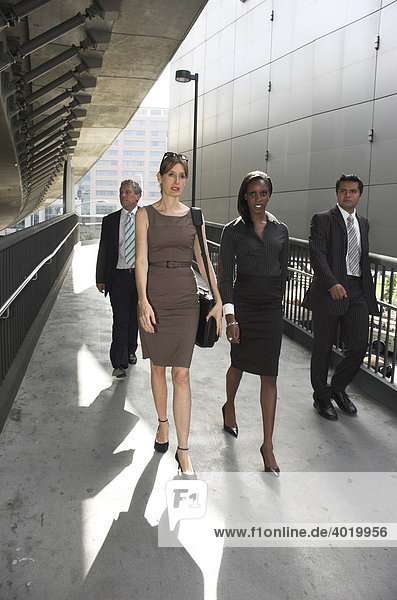 Group of business people walking through an urban passageway