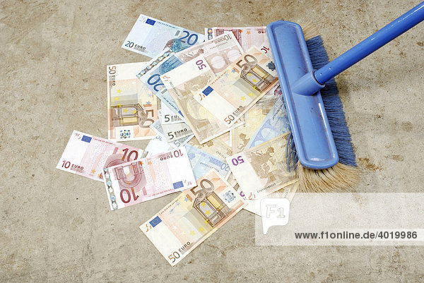 Euro Banknoten werden von einem Besen weggefegt