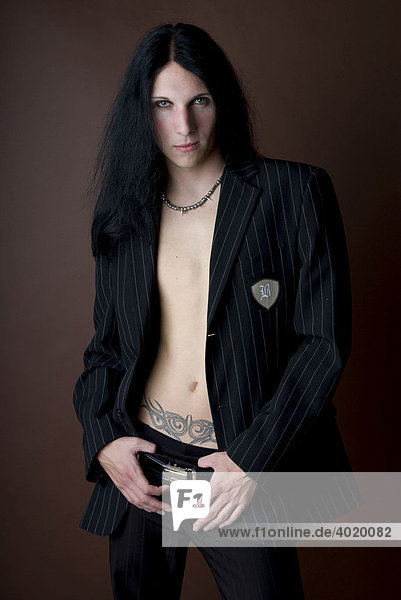 Male Gothic style musician with a tattoo and wearing a suit jacket