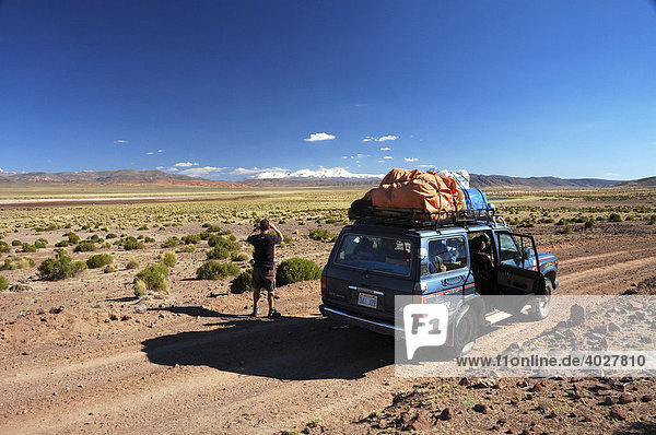 Junger Mann fotografiert die Gegend  Altiplano  Bolivien  Südamerika