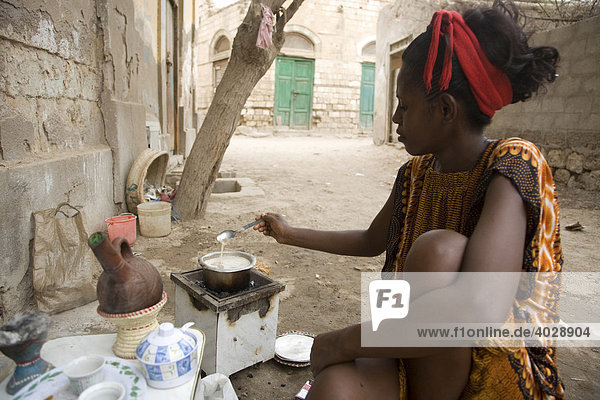 Eine junge Frau  20-25 Jahre  bereitet auf einem kleinen Holzkohleherd Brei für ihr Baby zu  Rotes Meer  Massawa  Eritrea  Afrika