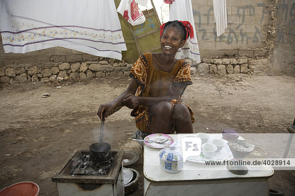 Junge Frau  20-25 Jahre  bei Kaffeezeremonie im Freien mit frisch gerösteten Kaffeebohnen bei hochsommerlichen Temperaturen von 45°C  Rotes Meer  Massawa  Eritrea  Afrika