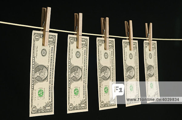 US Dollar Banknoten hängen an einer Wäscheleine