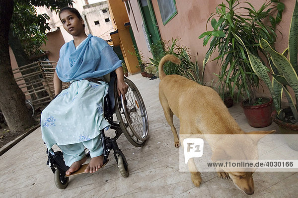 Salma Bibi  18  verbrachte die letzten zwei Jahre ihres Lebens im Bett. Sie litt unter einer schweren Spinaltuberkulose mit schweren Komplikationen. Die angegriffene Wirbelsäule wurde auf Kosten einer Hilfsorganisation operiert  doch sie wird trotzdem nie wieder laufen können. Vor dem St. Thomas Home  einer TB- Spezialklinik  fährt sie  zusammen mit Tiger  dem Klinikhund  die ersten Runden in ihrem Rollstuhl. Howrah  Hooghly  Westbengalen  Indien