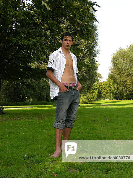 16-year-old boy wearing an unbuttoned shirt in a park