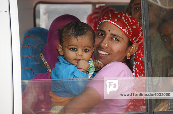 Indian woman holding a child in a fully occupied car  near Jodhpur  Rajasthan  North India  Asia