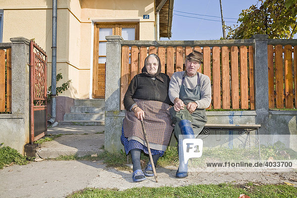 Romanian couple sitting on a bench in front of their house  Cernuc  Salaj  Transylvania  Romania  Europe