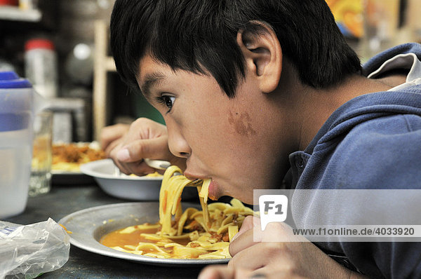 Hungry boy eating noodles  Slum Area Plan 3000  Santa Cruz  Bolivia  South America