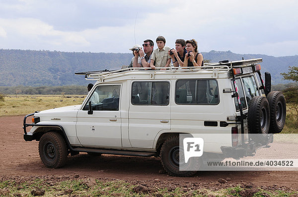 Tourists on safari in a four wheel drive vehicle  Lake Manyara National Park  Tanzania  Africa