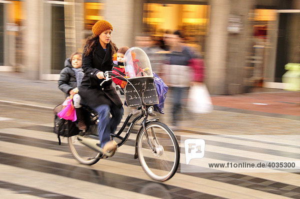 Cyclist with children in the city centre of Amsterdam  Holland  Netherlands  Europe