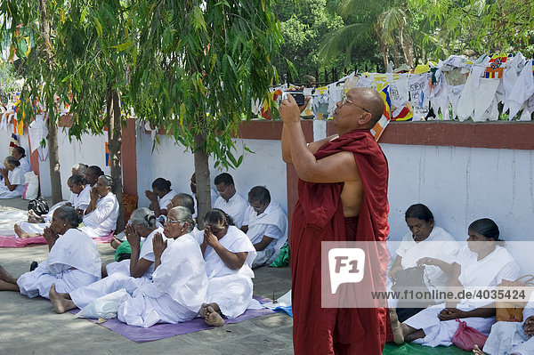 Monk filming in the Dhammachakkapavattana Sutta Memorial Park  Sarnath  Uttar Pradesh  India  South Asia