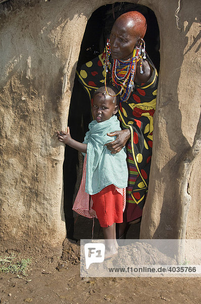 Masai mother and her child at the entrance to a hut  Masai Mara  Kenya  East Africa