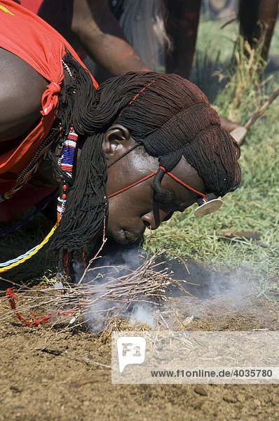 Masai Mann startet ein Feuer mit getrockneten Zweigen  Masai Mara  Kenia  Ostafrika  Afrika