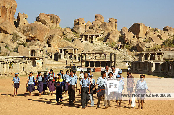 Indian school class in front of temple ruin and granite rocks  Hampi  Karnataka  India  South Asia