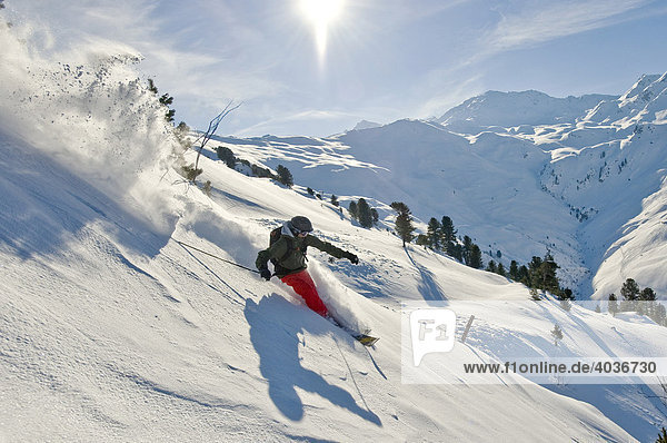 Tiefschnee Skifahrer  Freerider  im Tiefschnee mit Alpenpanorama und Sonne