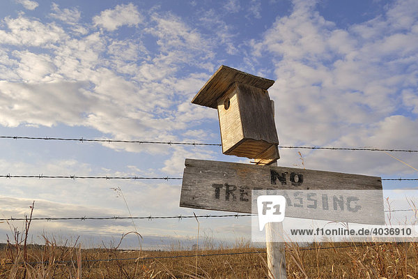 No Trespassing'  'Zutritt verboten'-Schild mit Vogelhäuschen an Zaun  Strathcona County  Alberta  Kanada  Nordamerika