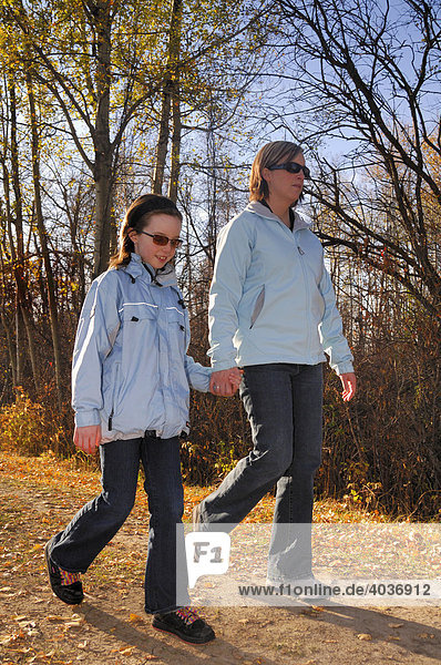 Mutter und Tochter spazieren im Herbst einen Wanderweg entlang  Strathcona County  Alberta  Kanada  Nordamerika