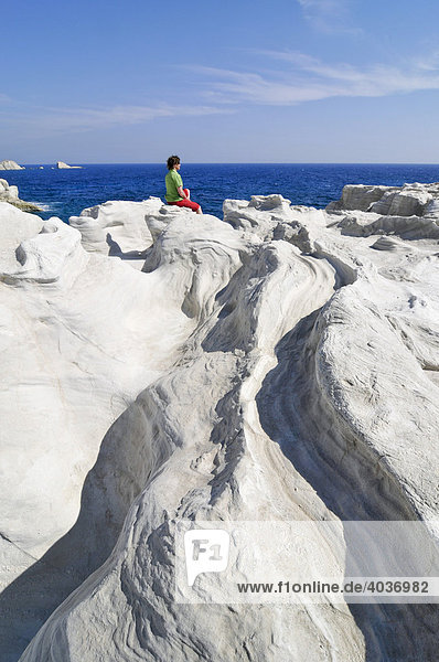 Woman sitting on white rock formations on Milos Island  Cyclades Island Group  Greece  Europe
