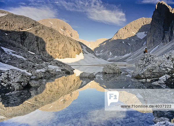 Wanderer sitzt am Bergsee Lago di Antermoia  Rosengarten  Südtirol  Italien  Europa