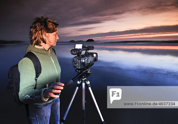 Kamerafrau mit Filmkamera filmt mit Stativ Sonnenuntergang am Meyers Creek Beach  Pistol River State Park  Oregon Küste  Oregon coast  USA  Nordamerika