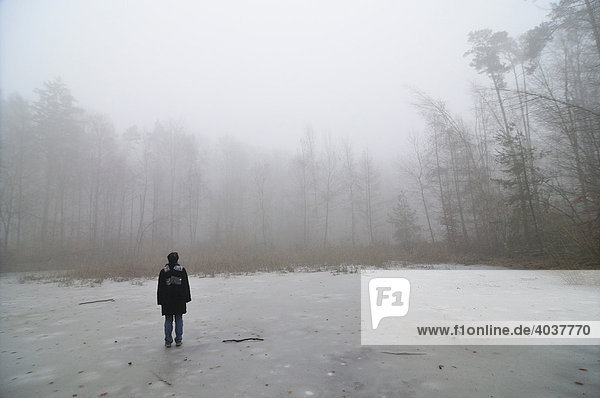 Person standing on a frozen pond in winter  Natural Park Schoenbuch  Baden-Wuerttemberg  Germany  Europe