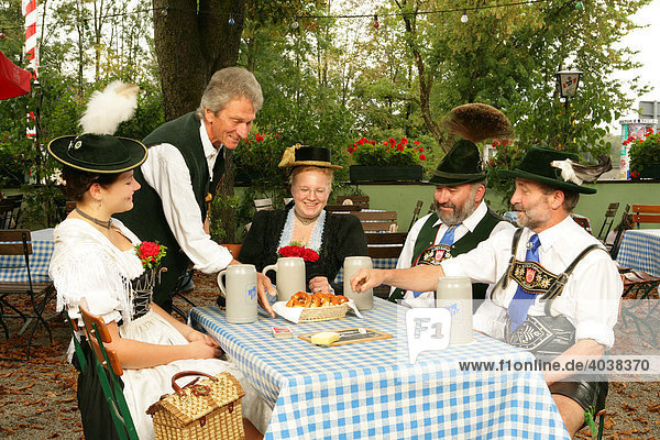 People in traditional costume in a beer garden  Muehldorf am Inn  Upper Bavaria  Germany  Europe