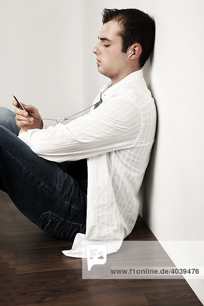 Young man listening to music with his MP3 player