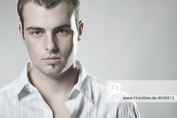 Portrait eines jungen Mannes mit weißem Hemd mit Blick in Kamera