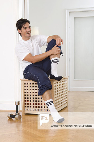 Young man wearing sport clothes and sport socks in the studio