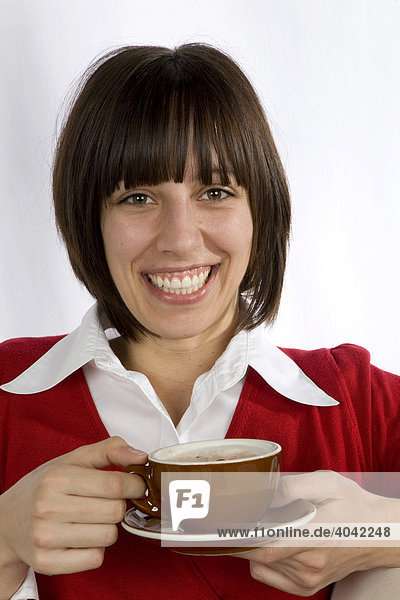 Frau  20-jährig  trinkt lachend Cappuccino
