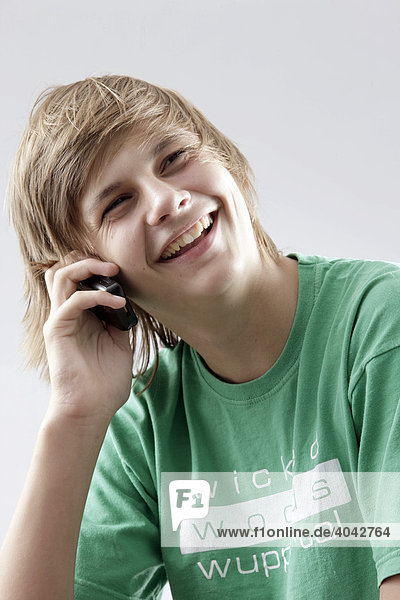13-jähriger Junge mit grünem T-Shirt telefoniert
