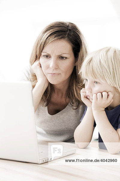 Mutter mit Sohn am Laptop  ratlos