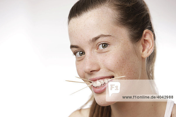 17-jähriges Mädchen im weißen Top  mit Zahnstochern  Nahaufnahme