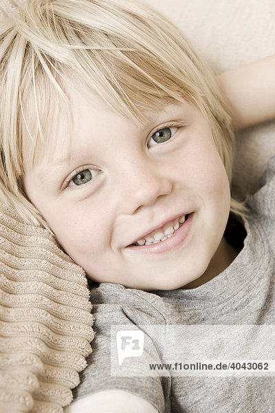 4-jähriger blonder Junge sieht in Kamera  lächelt