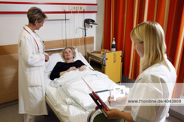 Ärztin spricht mit einer Patientin am Krankenbett im Krankenhaus