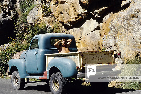 Alter Chevrolet Pick-up  junger Mann mit nacktem Oberkörper sitzt auf Ladefläche  Swartbergen  Kapprovinz  Südafrika  Afrika
