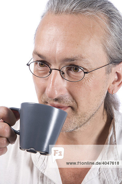Mann trinkt aus grauer Kaffeetasse