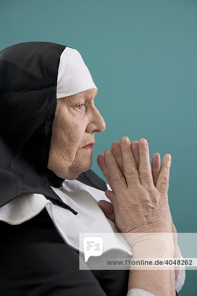 Alte Dame betet verkleidet als Nonne
