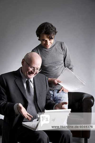Businessman and assistant working on a laptop