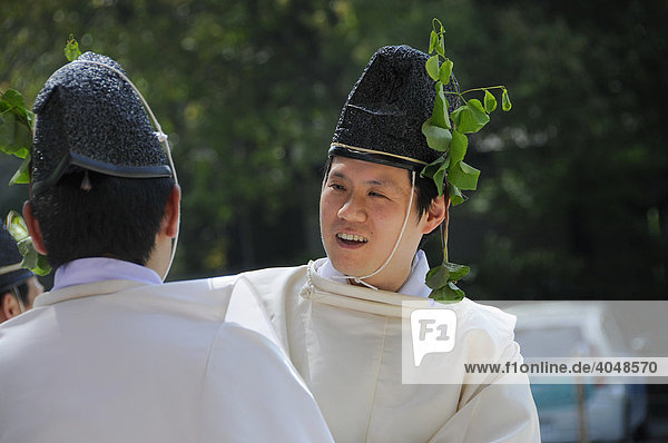 Shinto priests wearing headdress decorated with hollyhock leaves  at the Kamigamo Shrine  Kyoto  Japan