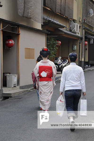 A Maiko  a trainee Geisha  walking with her assistant to the Odori in the Gion Quarter of Kyoto  Japan  Asia