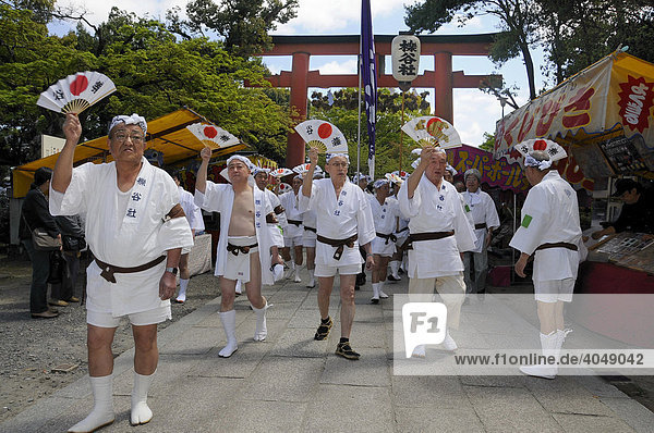 Handles of the shrines being carried accompanied by waving fans  Matsuri Shrine Festival of the Matsuo Taisha Shrine  Shinto  Kyoto  Japan  Asia