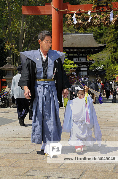 Procession attendee and his son in traditional costume in front of the Torii  Matsuri Shrine Festival of the Matsuo Taisha Shrine  Shinto  Kyoto  Japan  Asia