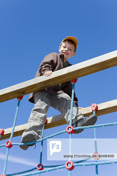 Boy  6 years old  climbing in a playground