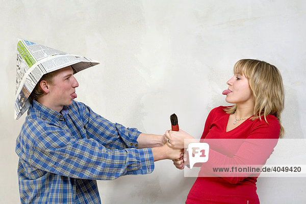 A young couple  22-year-old man and 20-year-old woman  with paper hat and paintbrush