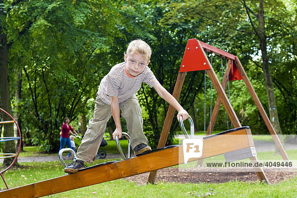 Boy  six years  clambering on a seesaw
