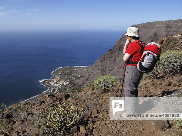 Frau mit Rucksack genießt Aussicht von Berg Las Pilas  La Playa im Valle Gran Rey  La Gomera  Kanaren  Kanarische Inseln  Spanien  Europa